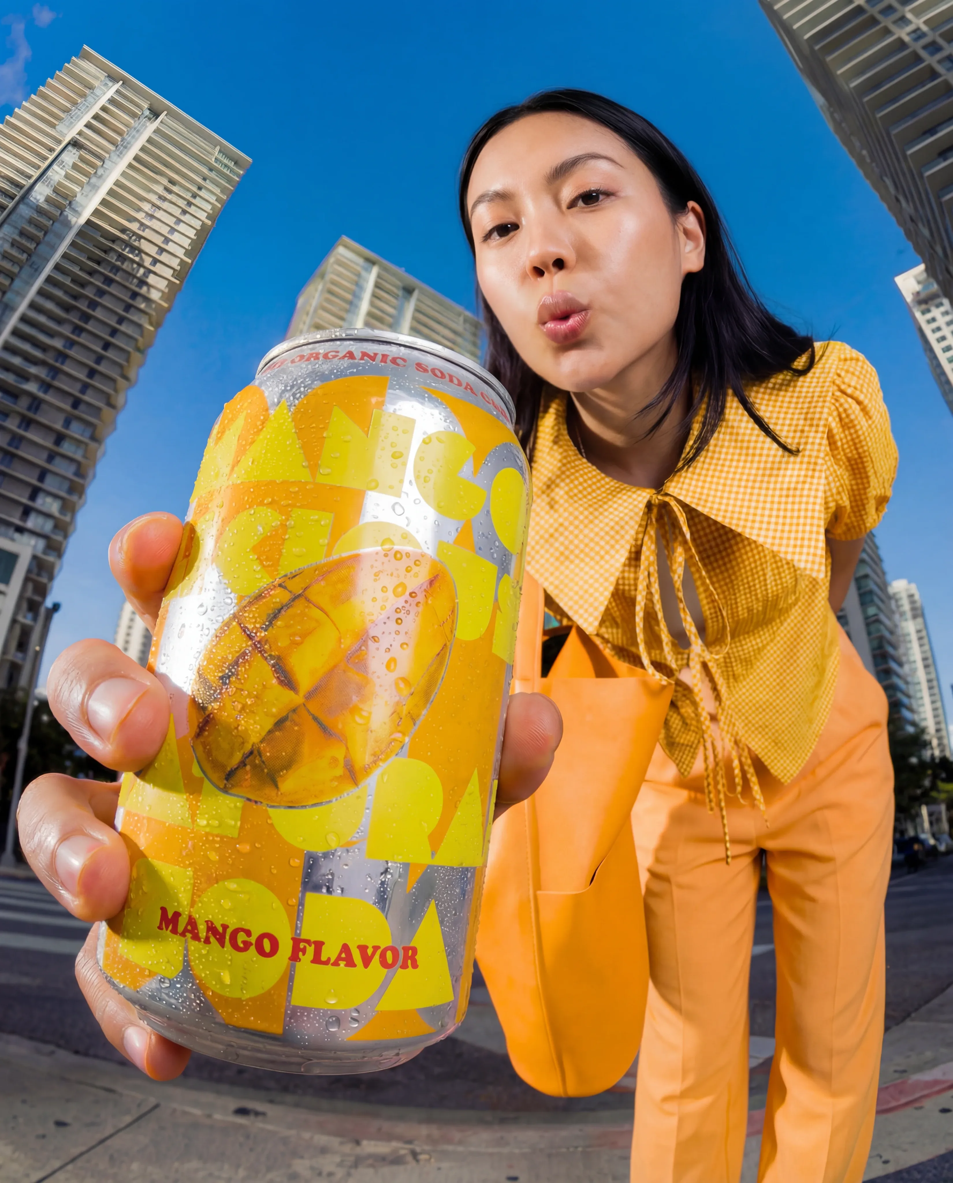 A model holding an oversized canned drink in a lifestyle scene.