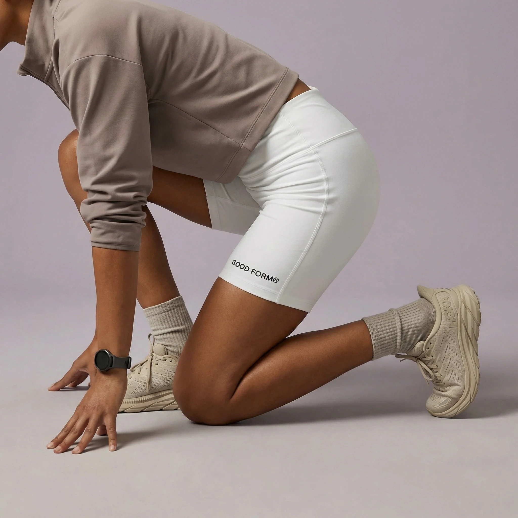 Sportswear editorial showing a model crouching in white training shorts