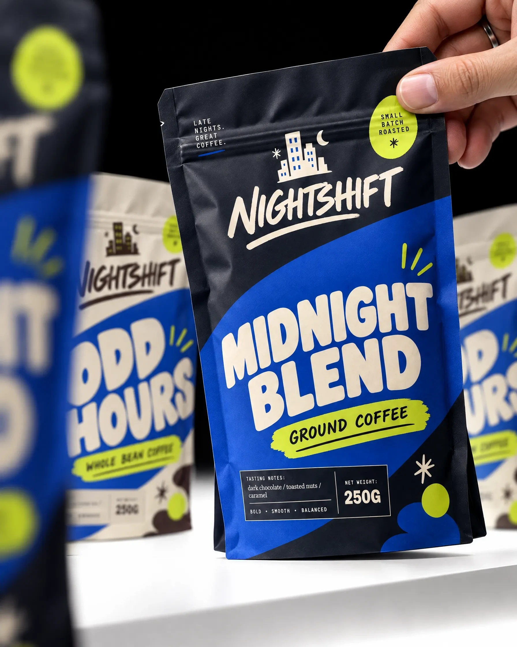 Hand holding a Nightshift Midnight Blend ground coffee pouch