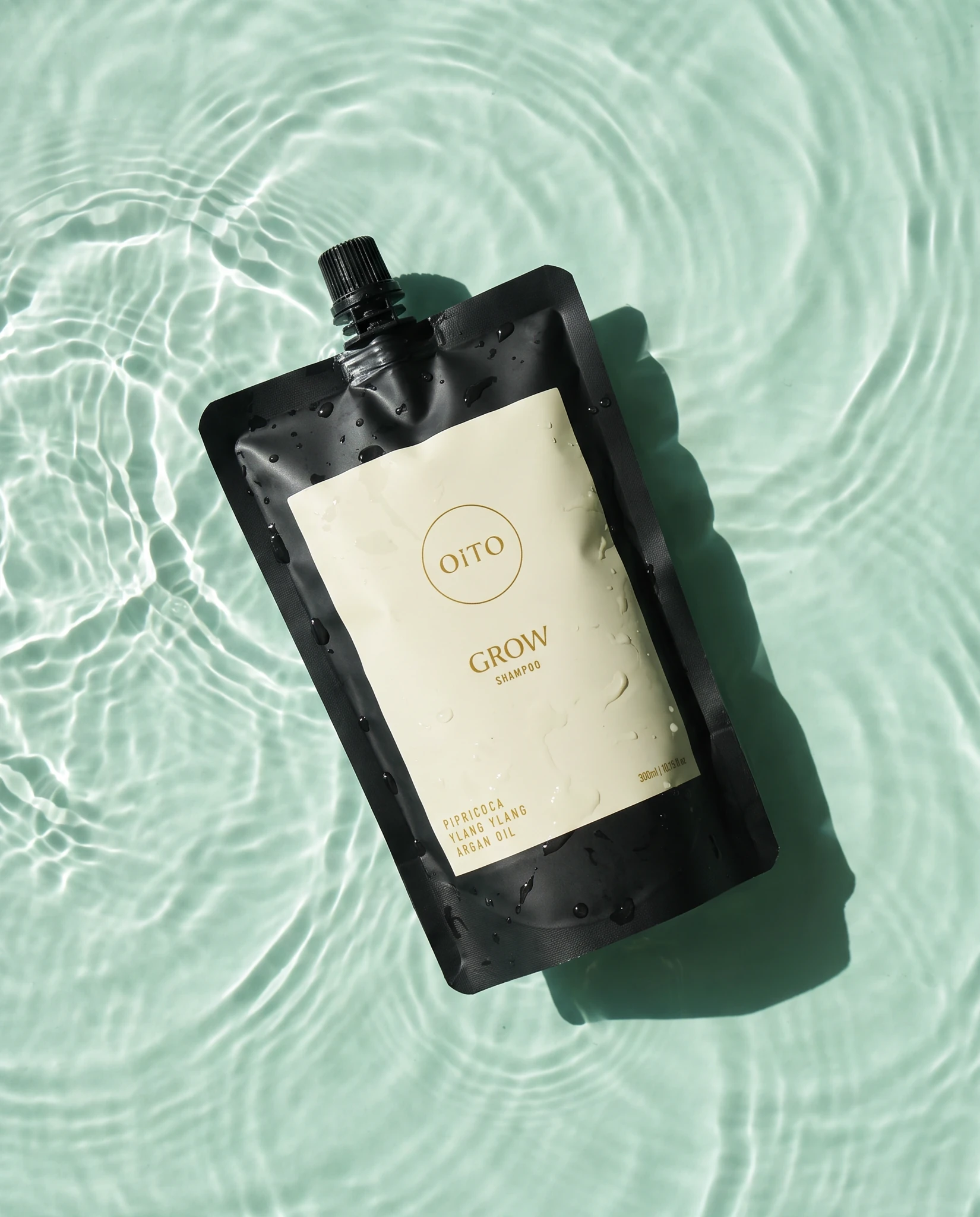 OiTO Grow Shampoo refill pouch floating in clear rippling water