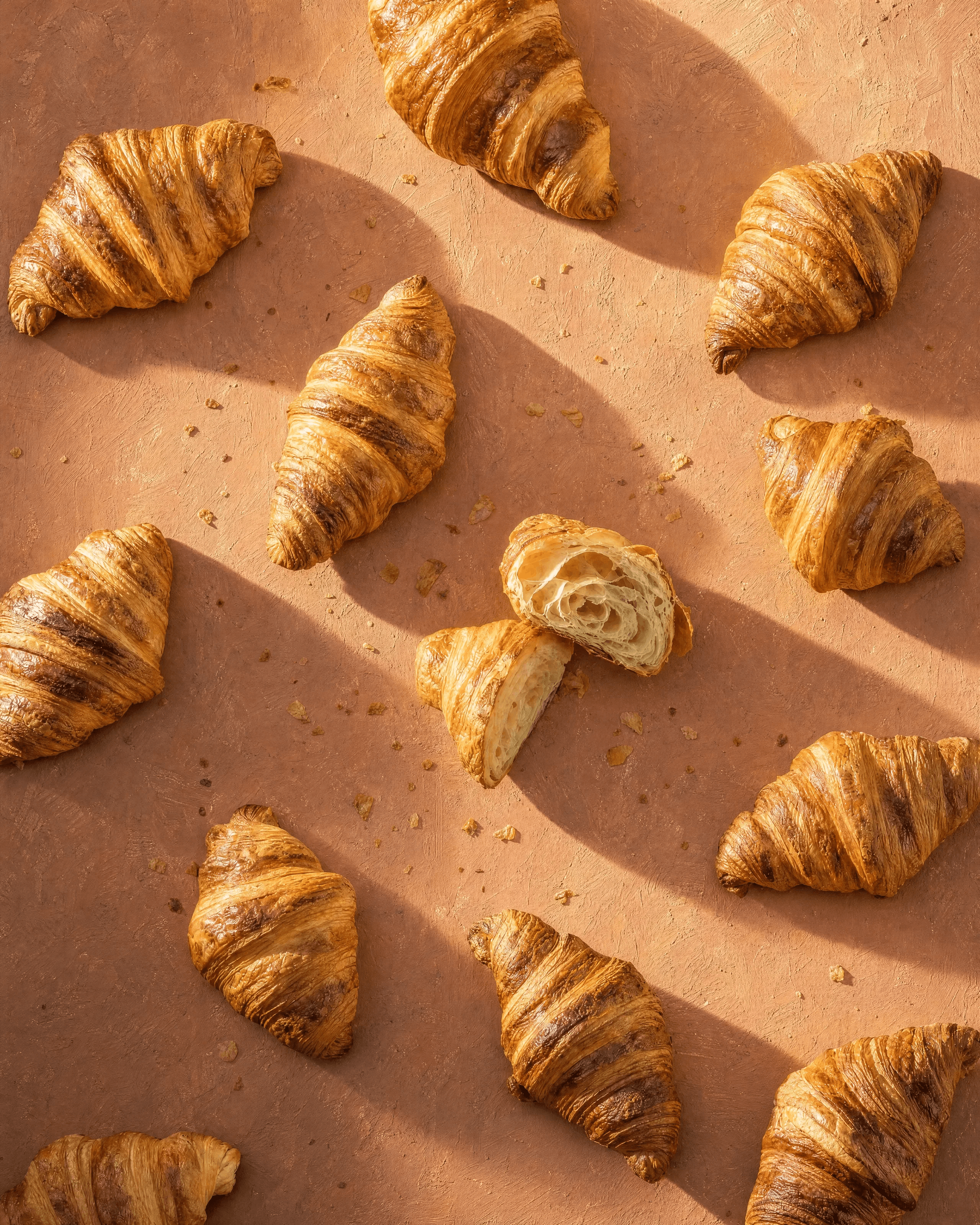 DORÉ: The Pattern — Croissants laid edge to edge on hand-painted terracotta board