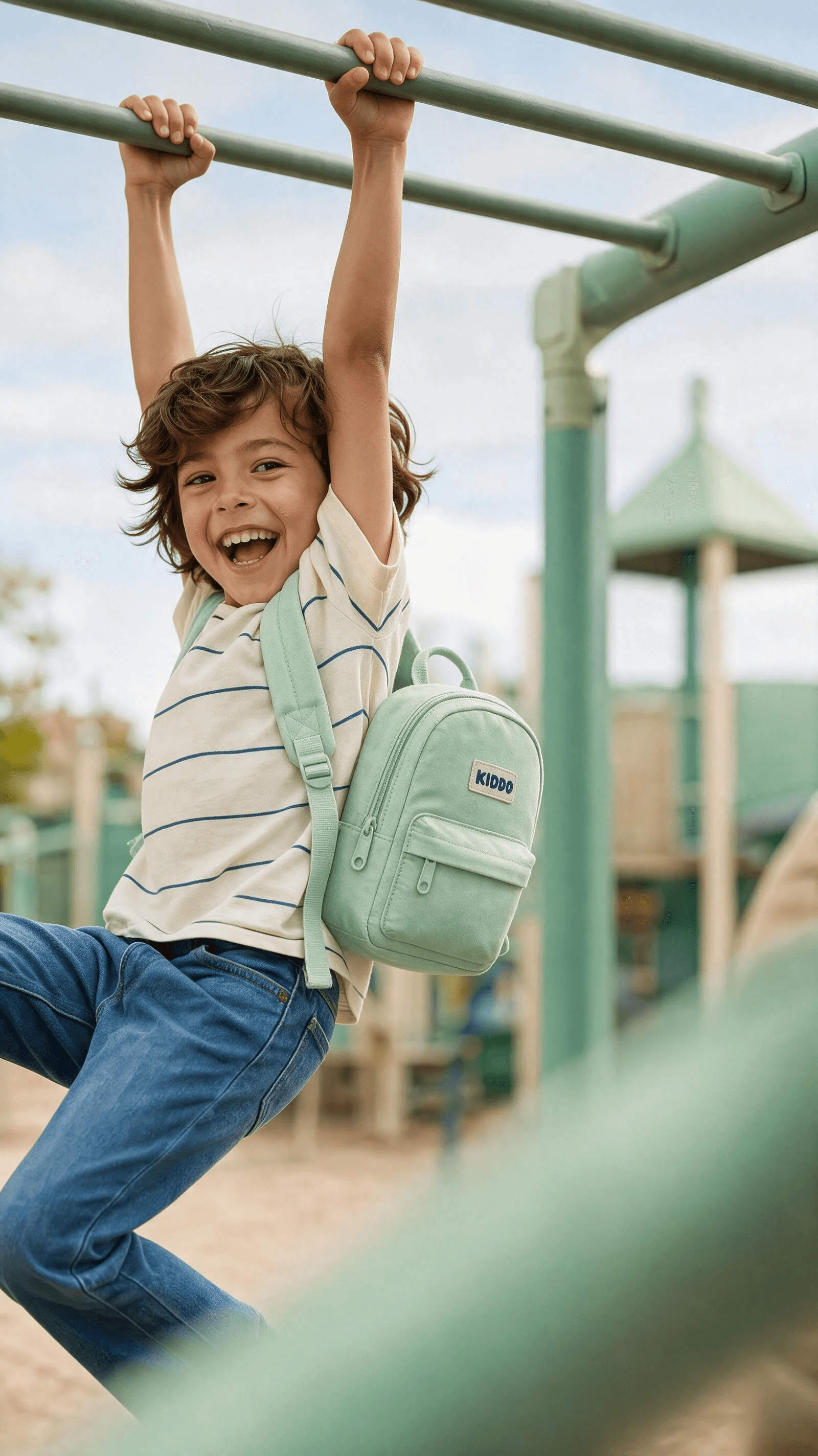 A playful monkey-bars portrait with a mint mini backpack and genuine motion.
