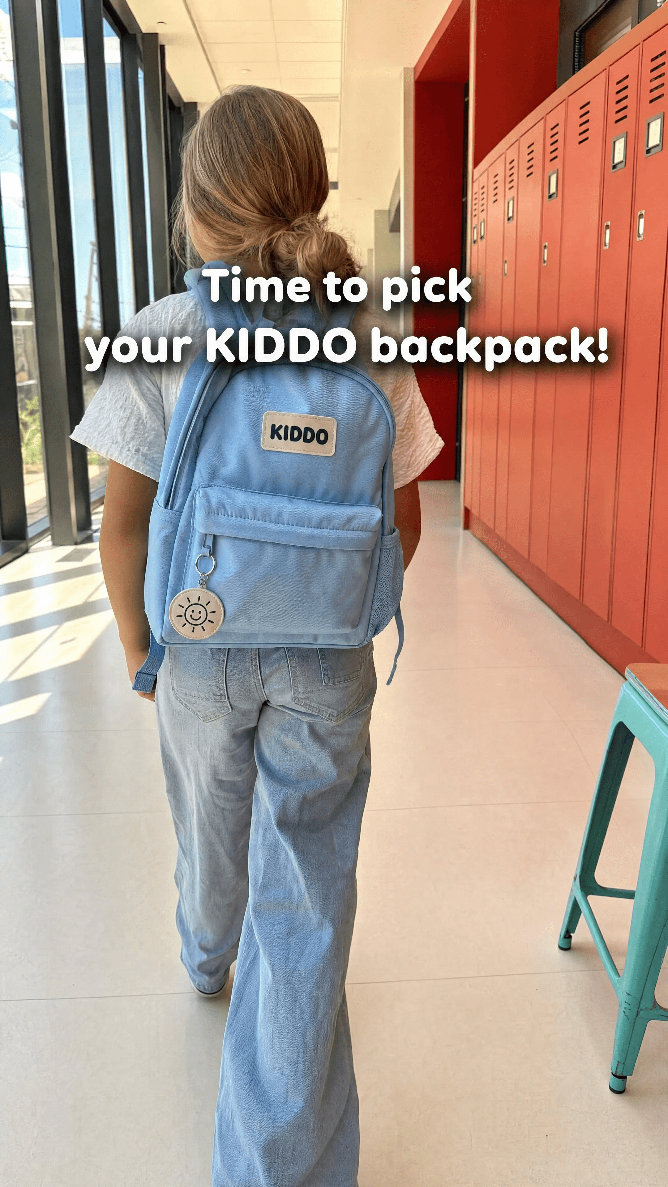 A native-social hallway shot of a child walking away with the sky-blue backpack.