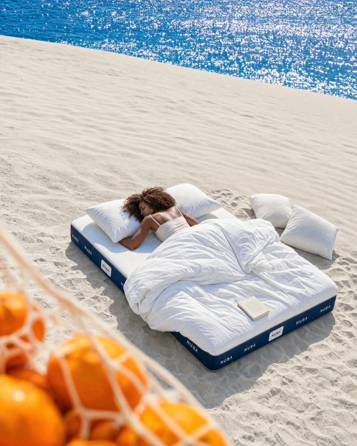 Model sleeping on a NUBA mattress among pale white dunes