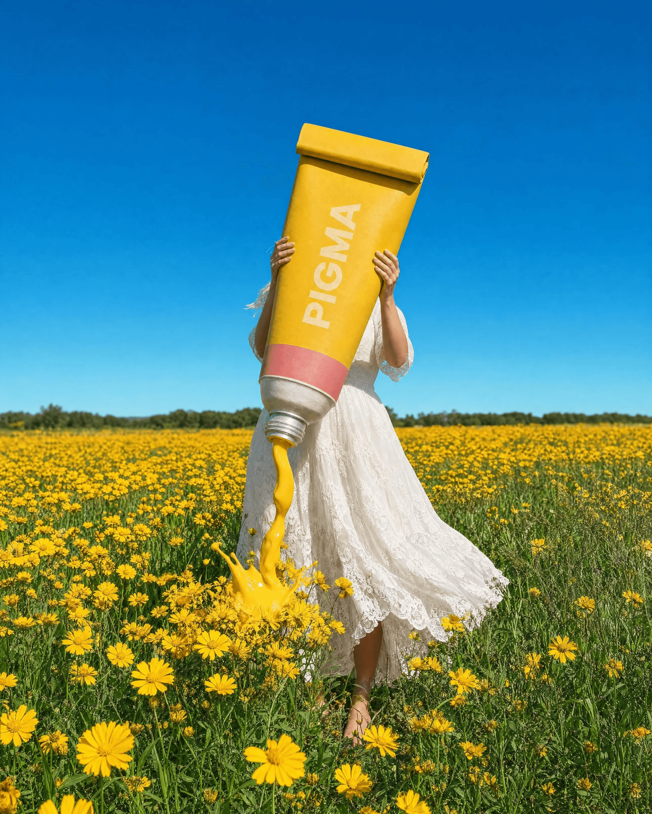 Woman holding a giant yellow PIGMA paint tube in a wildflower field