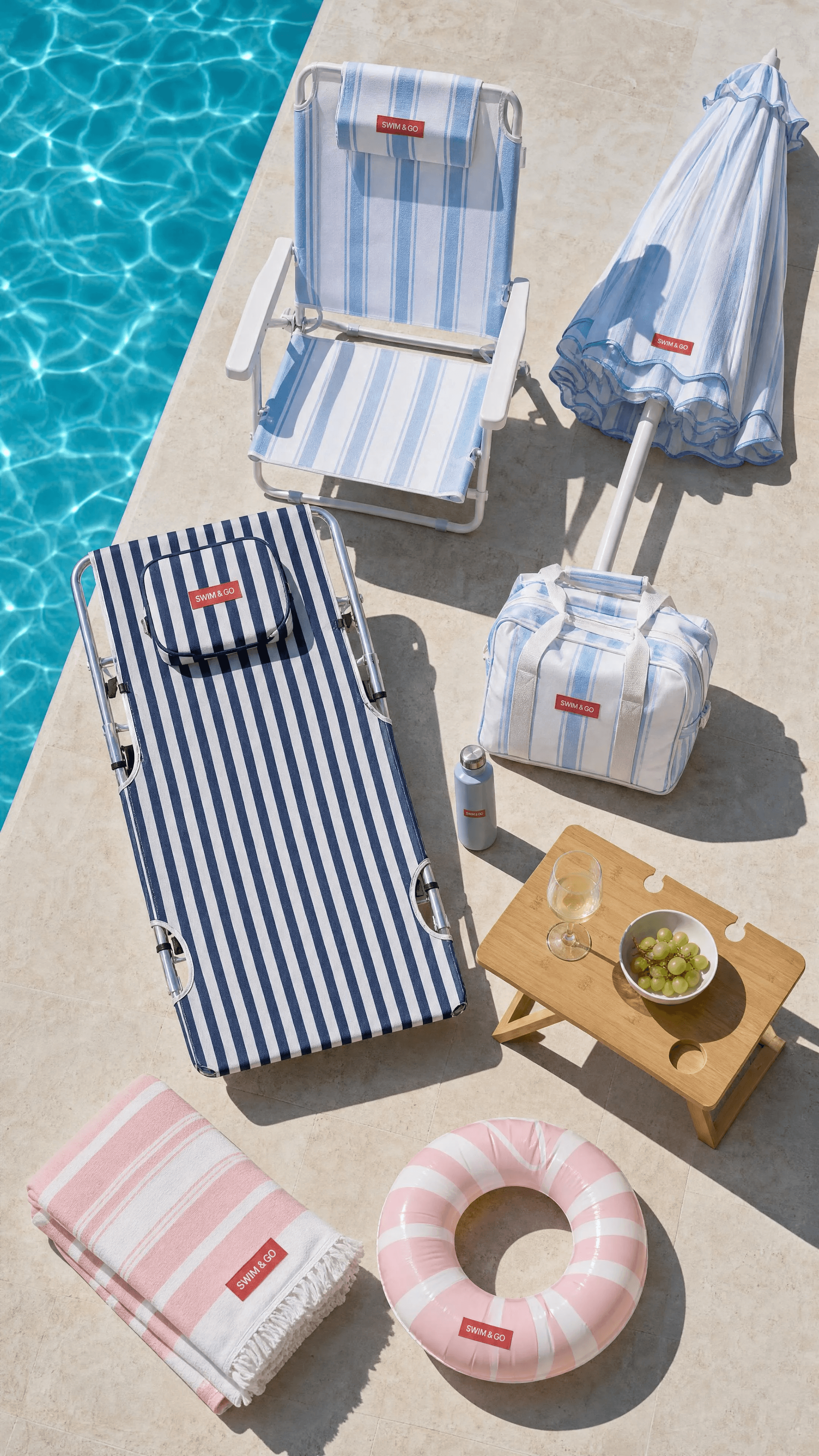 Blue, navy, and pink SWIM & GO accessories in a poolside overhead composition