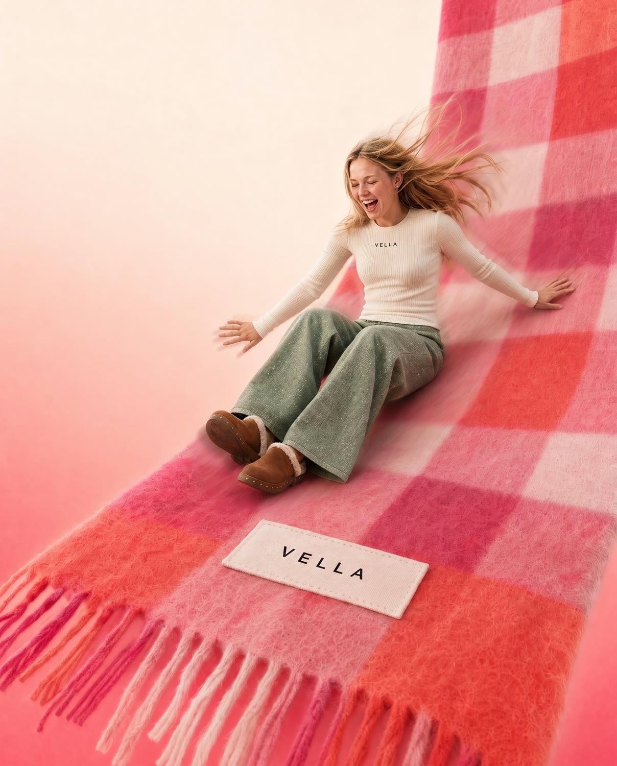 Model sliding down a giant pink and coral VELLA FRESA cape
