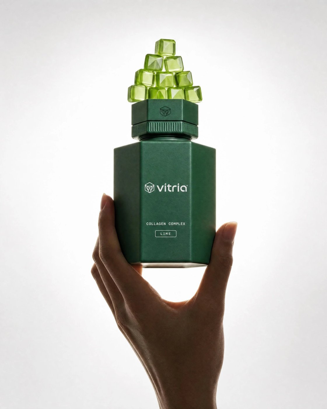 VITRIA: Held Up To The Light — Lime raised overhead, gem-cut gummies catching the light