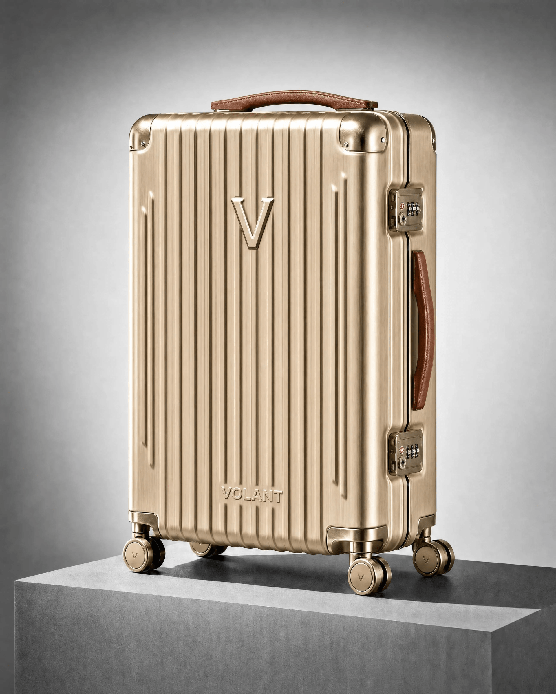 Champagne-gold VOLANT cabin suitcase on a stone plinth